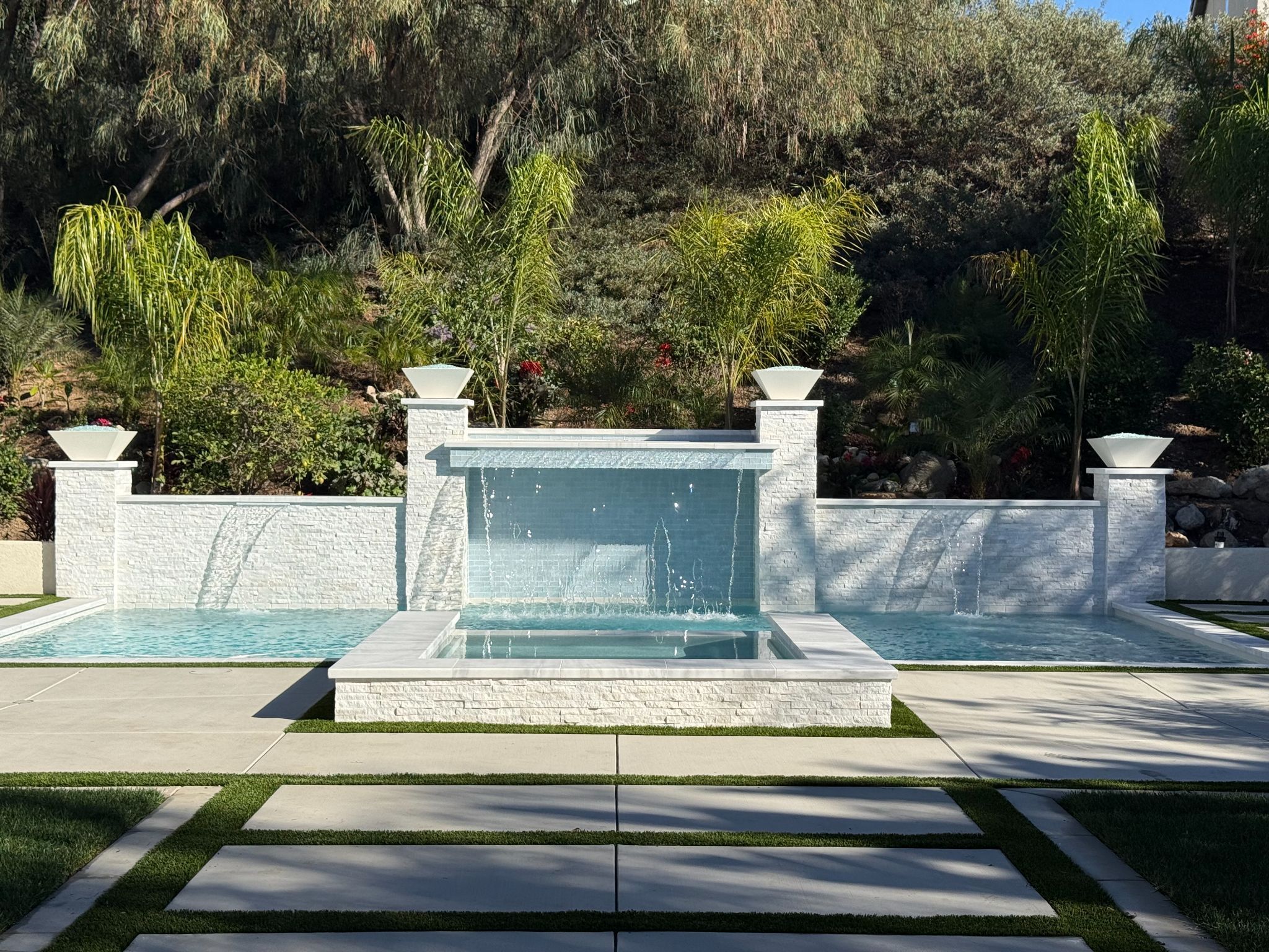 Luxury backyard pool with spa and white waterfall wall