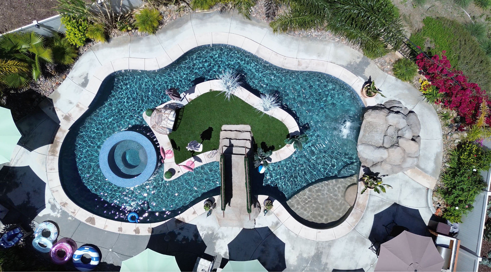 Aerial view of resort-style pool with spa and island patio