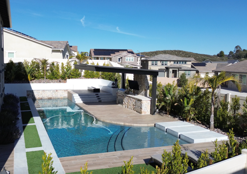 Modern backyard pool with outdoor kitchen and pergola