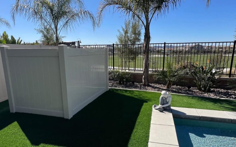 vinyl fence, green turf, fence and palm trees