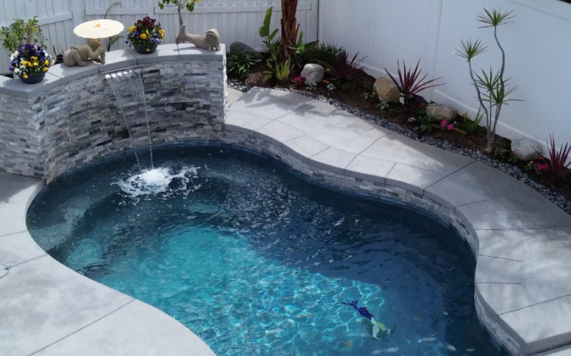 pool, stone waterfall, by Majestic Pool Construction in his blog, When Is the Best Time to Start Building a Pool in Southern California?